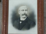 portrait of a man with a mustache and glasses in a wooden frame