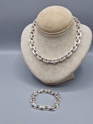 un ensemble composé d'un collier et d'un bracelet en argent, présenté sur un mannequin