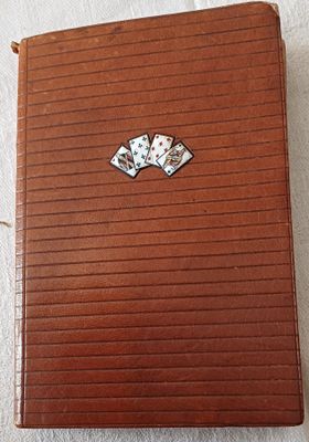 étui en cuir marron sur lequel figurent quatre cartes à jouer sur un fond blanc