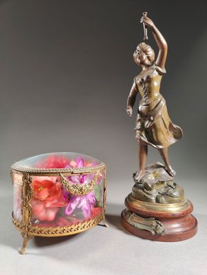 a statue of a woman holding a flower next to a box