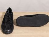 a pair of black shoes sitting on top of a wooden table