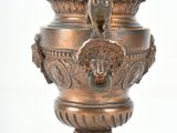 a bronze urn with a bird on top of it