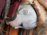 a close up of a doll with a red hat on