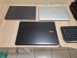 trois ordinateurs portables et un clavier posés sur une table