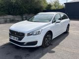 la voiture blanche est garée dans le parking à côté d'un bâtiment