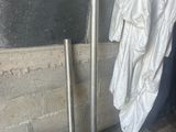 a white shirt hanging on the wall next to a metal pole