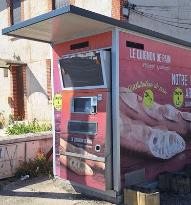 un distributeur automatique rose sur le côté d'un immeuble