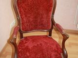 a red chair that is sitting on a wooden floor