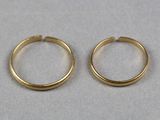 deux boucles d'oreilles en anneau dorées sur un fond blanc