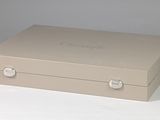 a tan box with a silver handle on a white surface