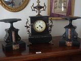 trois horloges posées sur une table, avec un miroir en arrière-plan