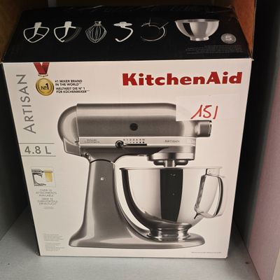 une boîte contenant un robot de cuisine « KitchenAid » posée sur une étagère