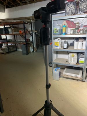 a camera on a tripod in a room with shelves
