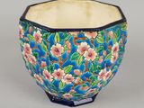 un bol bleu orné de fleurs roses et de feuilles vertes