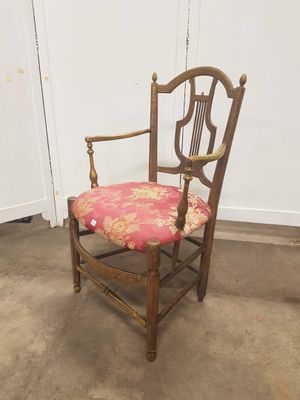 une image représentant une chaise avec un coussin rose posé dessus, dans une pièce