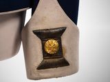 a close up of a uniform with a gold coin on it