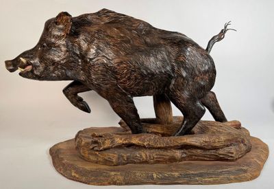 statue d'un sanglier posée sur un socle en bois, sur fond blanc