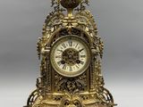 a gold clock sitting on top of a table