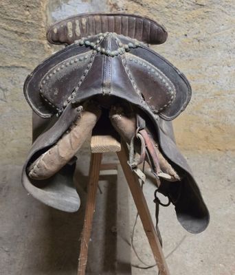 une selle de cheval posée sur un support en bois