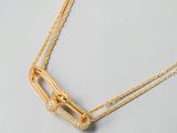 gros plan d'un collier en or sur une surface blanche