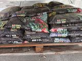 many bags of food sitting on a pallet in a warehouse