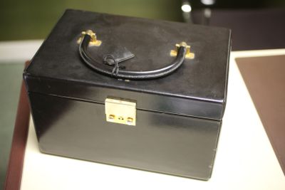 une boîte noire munie d'une poignée, posée sur une table