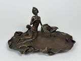 une image d'une statue en bronze représentant une femme tenant un oiseau