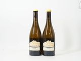deux bouteilles de vin posées l'une à côté de l'autre sur une surface blanche