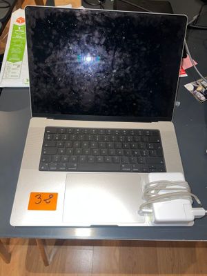 a laptop computer sitting on a table with a charger on it