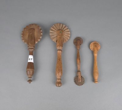 Plusieurs cuillères et spatules en bois sont alignées sur une surface grise