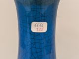 a blue vase sitting on a table with a sticker on it