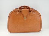 a brown leather suitcase sitting on top of a white surface