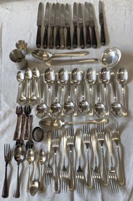 a lot of silverware on a table with a white cloth