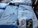 deux sacs de riz posés sur un lit devant une fenêtre
