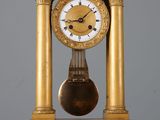 une horloge en or posée sur une table blanche