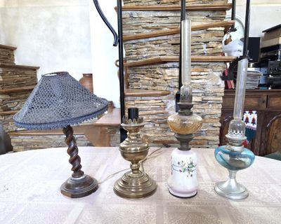 trois lampes posées sur une table devant un mur de pierre