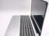 a silver laptop with a black keyboard on a white surface