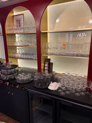 Des bouteilles et des verres sont alignés sur le comptoir d'une cave à vin