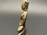 an ancient bronze figurine of a woman holding a bird