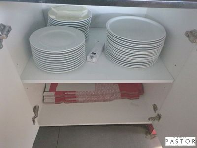 de nombreuses assiettes blanches empilées sur une étagère dans la cuisine