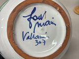 a close up of a vase with a signed label on it