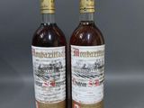 deux bouteilles de vin posées l'une à côté de l'autre sur une table