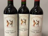 trois bouteilles de vin rouge posées sur une table blanche