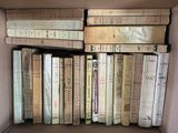 a box full of old books sitting on a shelf