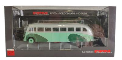un petit bus jouet vert et blanc dans une boîte