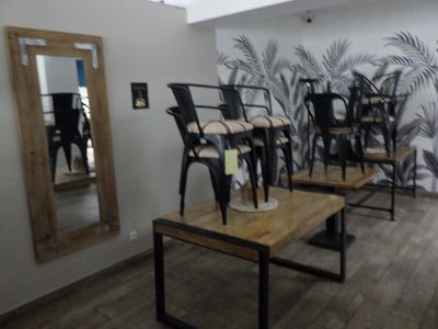 plusieurs chaises et tables dans une pièce où un miroir est accroché au mur