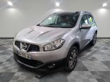 La Nissan QXV argentée est garée dans une pièce au sol à carreaux.