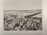 a black and white photo of a city with a bridge in the background
