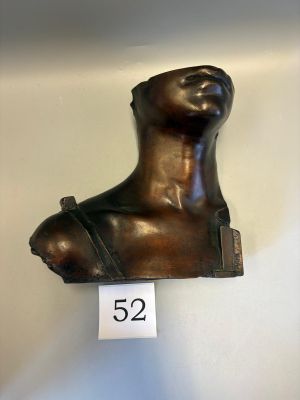 a bronze bust of a woman on display on the wall