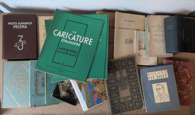 beaucoup de livres posés sur une table, avec une personne debout à côté